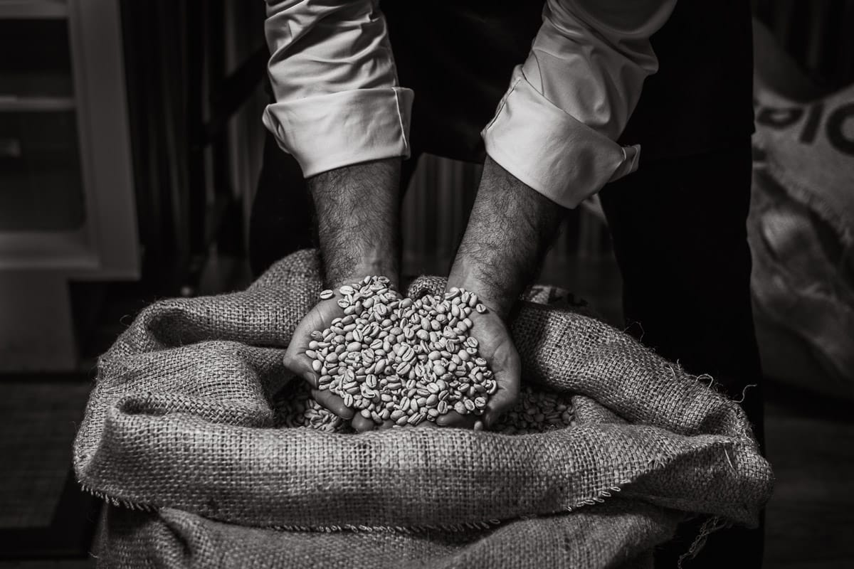 Personal branding photo of a man with his hands in a bag of coffee beans