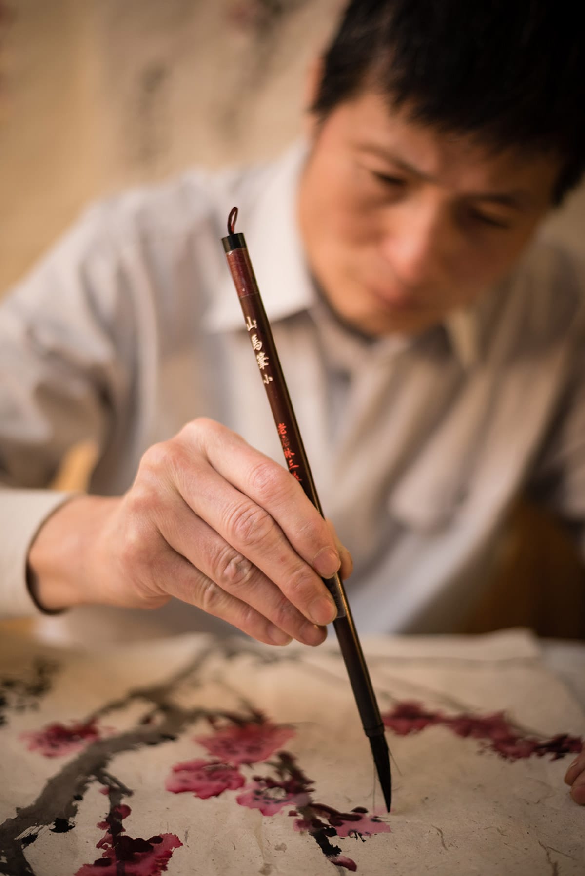 personal branding photo of a man painting a tree with pink leaves