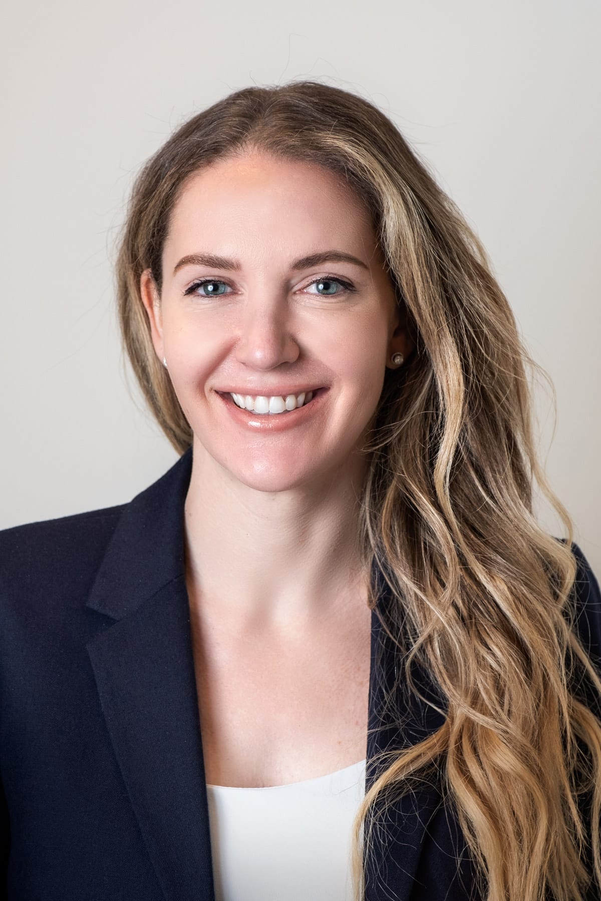 Corporate and professional headshot of young woman in a blue suit